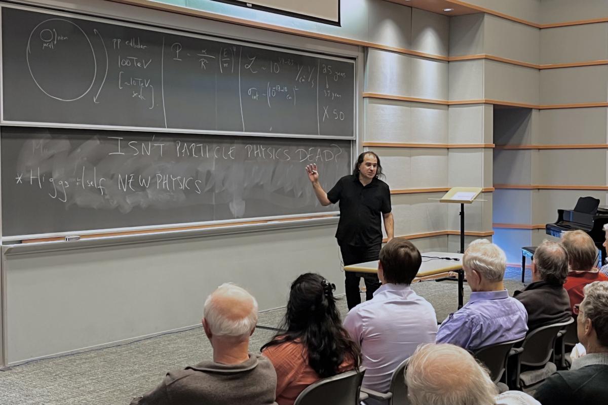 Particle physics isn’t dead,” reads the blackboard behind an expressive physicist presenting to a packed audience.