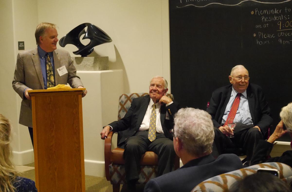 Lars standing at the podium next to Glen and Charlie, both seated